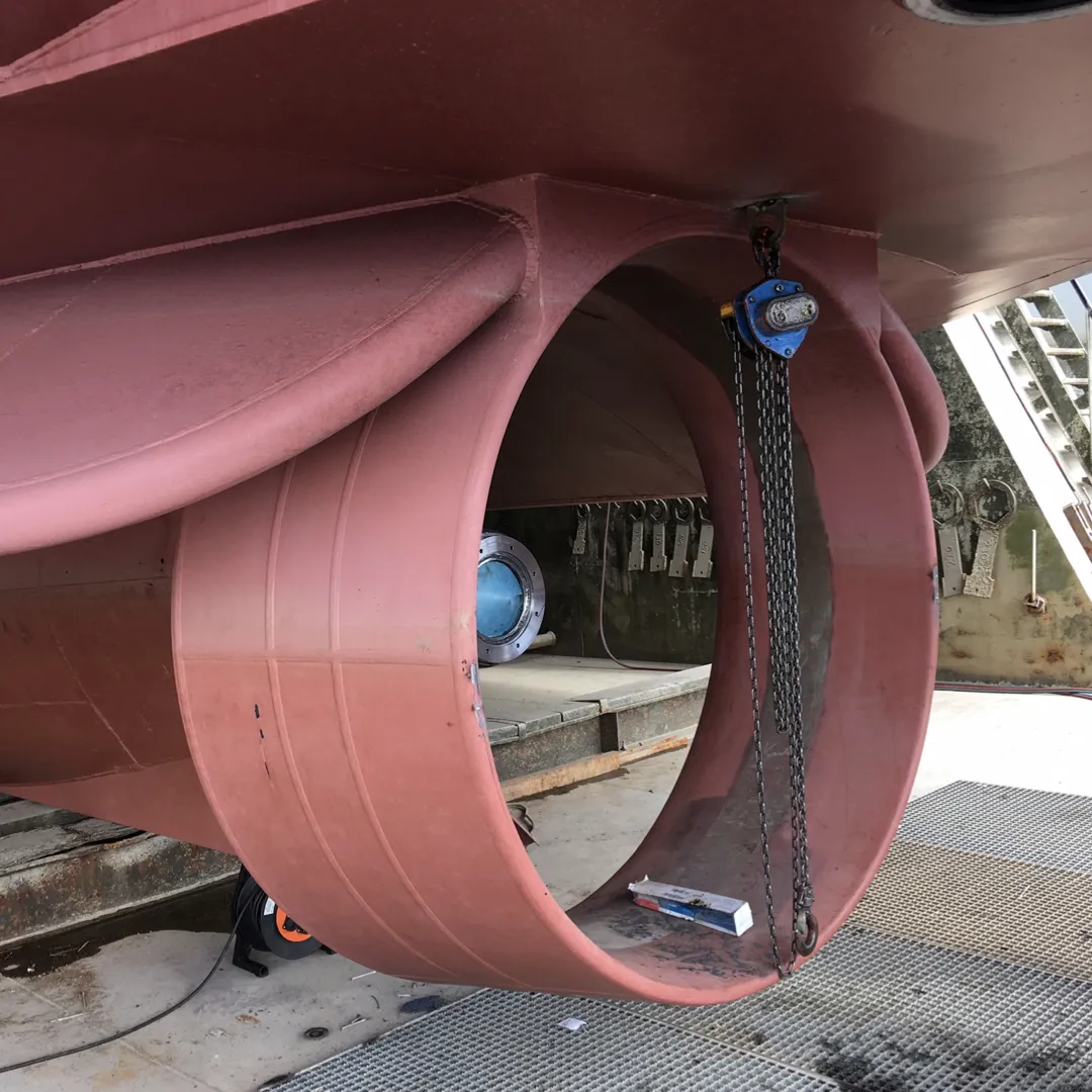 This image shows a close-up of a CFD-optimized propeller nozzle being installed under a ship.