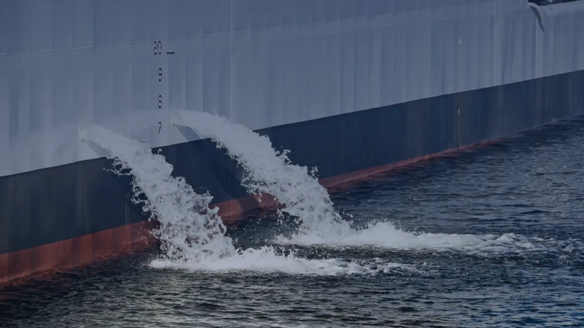 Ship discharges treated ballast water with a BWTS that meets IMO and USCG requirements.