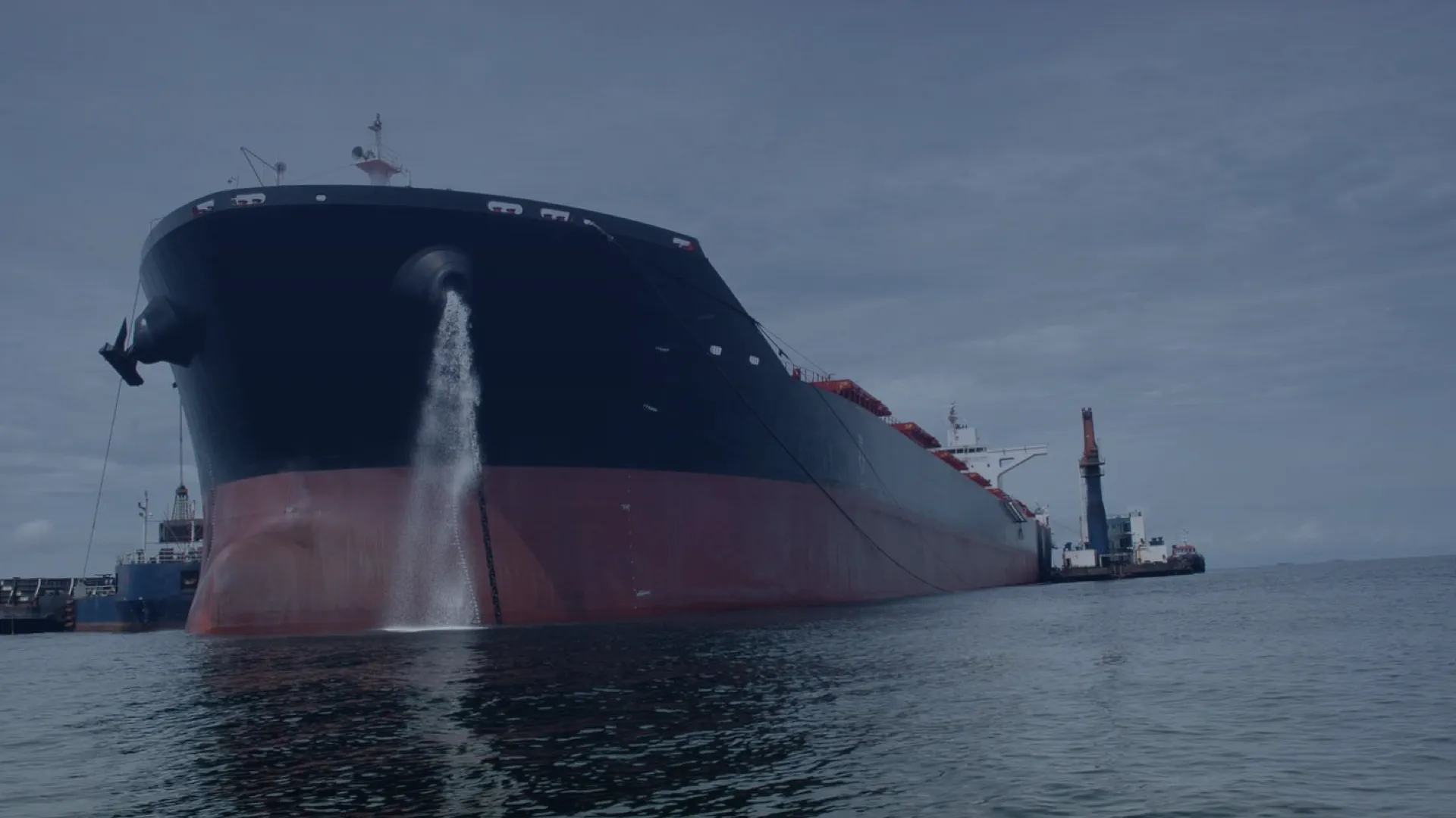 A ship discharges ballast water using a UV-based ballast water treatment system (BWTS) to prevent the spread of invasive species.